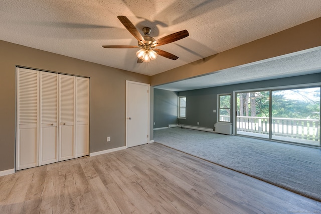 118 Sheraton Ln Unit 118, Norwich, CT 06360 - unfurnished bedroom featuring a baseboard radiator, a textured ceiling, access to exterior, light wood-style flooring, and ceiling fan