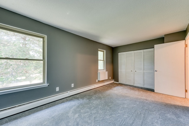 118 Sheraton Ln Unit 118, Norwich, CT 06360 - unfurnished bedroom featuring a baseboard radiator, carpet flooring, a closet, and a textured ceiling