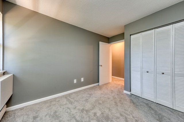 118 Sheraton Ln Unit 118, Norwich, CT 06360 - unfurnished bedroom featuring carpet, a closet, and a textured ceiling