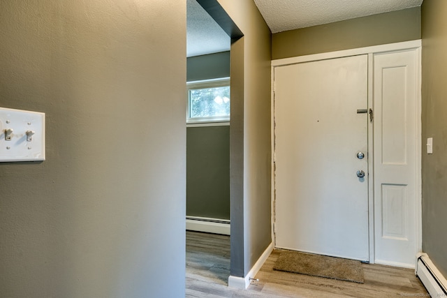 118 Sheraton Ln Unit 118, Norwich, CT 06360 - entrance foyer with baseboard heating, wood finished floors, and a textured ceiling