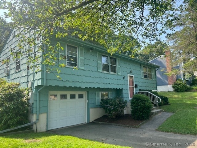 35 Corey Ln, East Lyme, CT 06357 - view of front of house with an attached garage, a front yard, and asphalt driveway