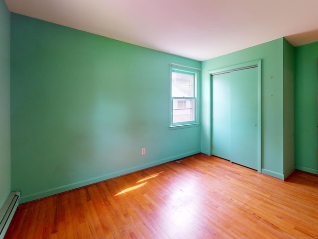 35 Corey Ln, East Lyme, CT 06357 - unfurnished bedroom with a baseboard radiator, light wood-style floors, and a closet