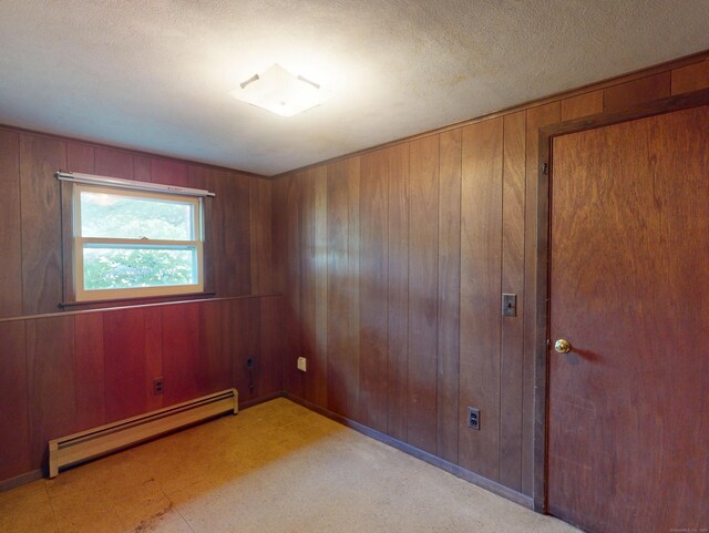35 Corey Ln, East Lyme, CT 06357 - unfurnished room featuring a baseboard radiator, wood walls, and a textured ceiling