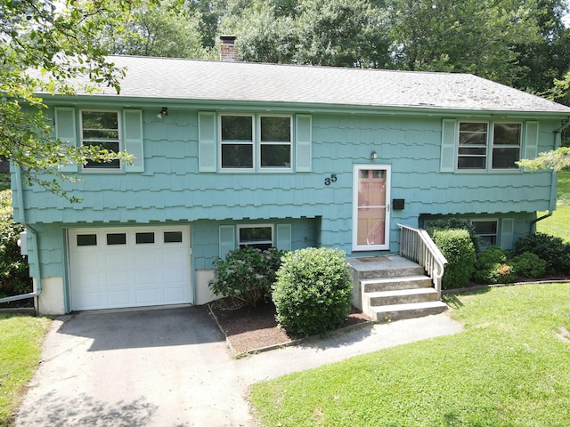 35 Corey Ln, East Lyme, CT 06357 - bi-level home with a chimney, an attached garage, concrete driveway, a front yard, and a shingled roof