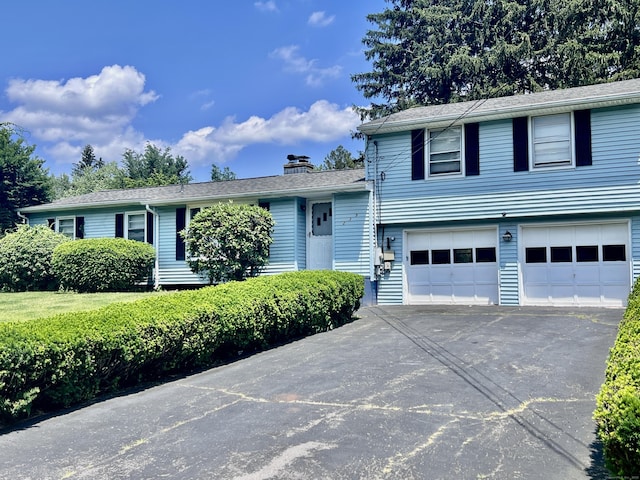 239 Bates Dr, Cheshire, CT 06410 - view of front of house featuring a garage, driveway, and a chimney