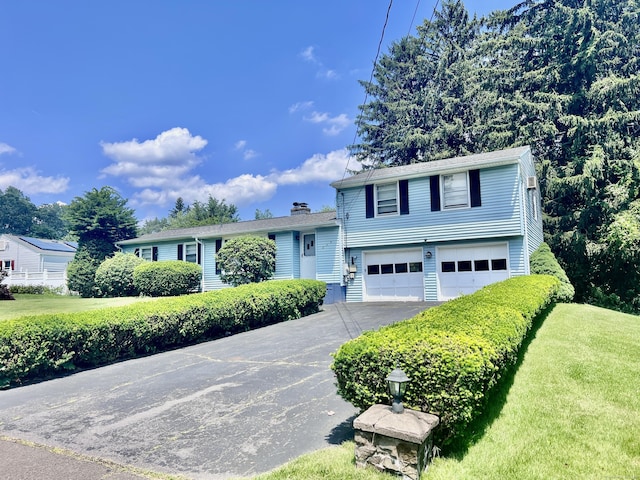 239 Bates Dr, Cheshire, CT 06410 - view of front facade featuring asphalt driveway, an attached garage, a chimney, and a front yard