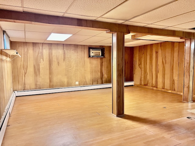 239 Bates Dr, Cheshire, CT 06410 - finished below grade area with a drop ceiling, a baseboard heating unit, wood finished floors, a wall unit AC, and wood walls