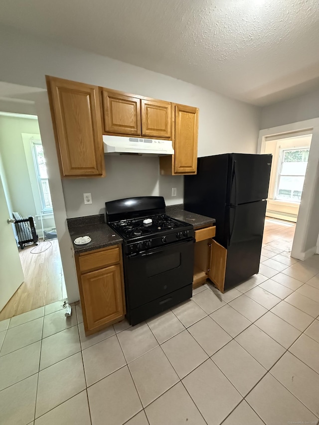 14 Market St, New Haven, CT 06513 - kitchen with black appliances, under cabinet range hood, a textured ceiling, light tile patterned flooring, and brown cabinetry