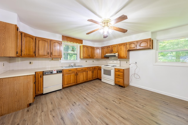510 Sylvan Lake Rd, Watertown, CT 06779 - kitchen with white appliances, under cabinet range hood, brown cabinetry, and tasteful backsplash