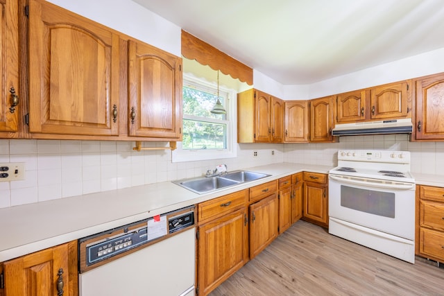 510 Sylvan Lake Rd, Watertown, CT 06779 - kitchen with white appliances, under cabinet range hood, brown cabinets, and tasteful backsplash