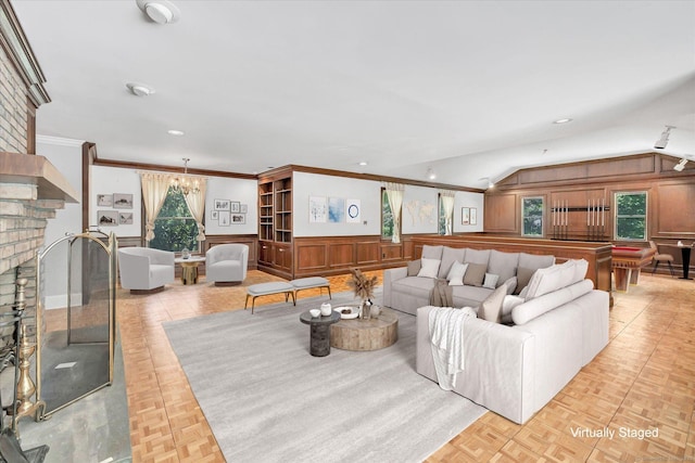 5550 Main St, Stratford, CT 06614 - living room featuring a chandelier, ornamental molding, vaulted ceiling, recessed lighting, and wainscoting