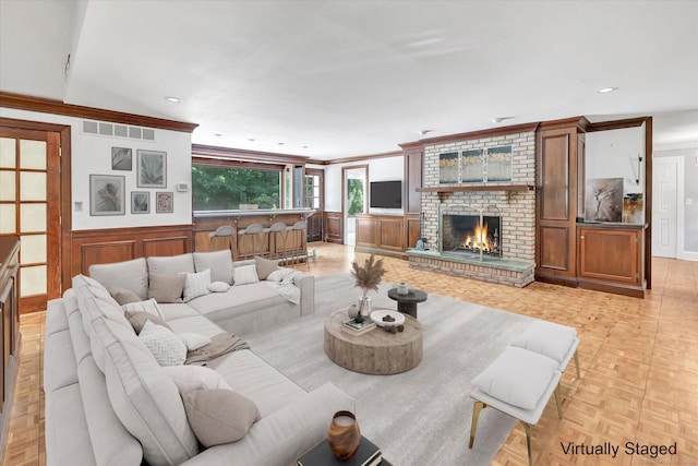 5550 Main St, Stratford, CT 06614 - living room featuring a brick fireplace, crown molding, a decorative wall, wainscoting, and recessed lighting
