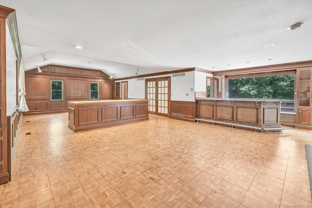 5550 Main St, Stratford, CT 06614 - kitchen with lofted ceiling, healthy amount of natural light, brown cabinetry, a decorative wall, and a kitchen island