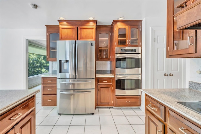 5550 Main St, Stratford, CT 06614 - kitchen with appliances with stainless steel finishes, light tile patterned floors, brown cabinets, light countertops, and recessed lighting