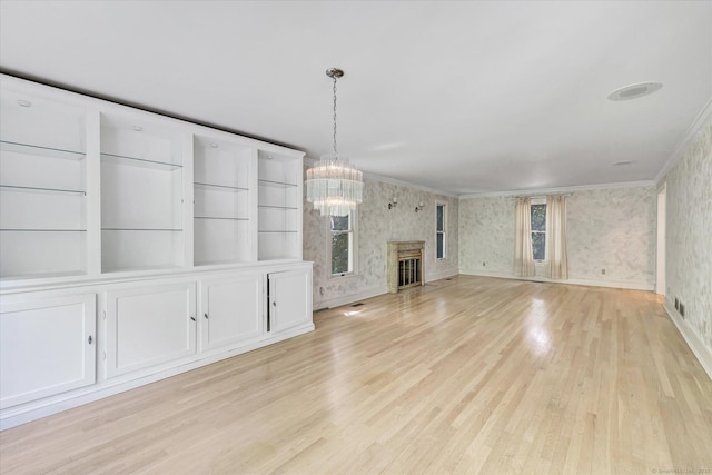5550 Main St, Stratford, CT 06614 - unfurnished living room with wallpapered walls, crown molding, a chandelier, and light wood-style floors