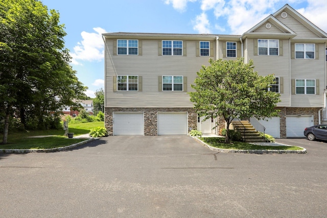 27 Riverview Ct Unit 27, Brookfield, CT 06804 - view of front of house featuring an attached garage, asphalt driveway, stairway, and stone siding