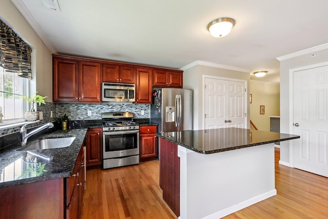 27 Riverview Ct Unit 27, Brookfield, CT 06804 - kitchen with stainless steel appliances, light wood-style floors, decorative backsplash, ornamental molding, and a kitchen island