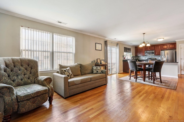 27 Riverview Ct Unit 27, Brookfield, CT 06804 - living room featuring a chandelier, crown molding, and light wood-style flooring