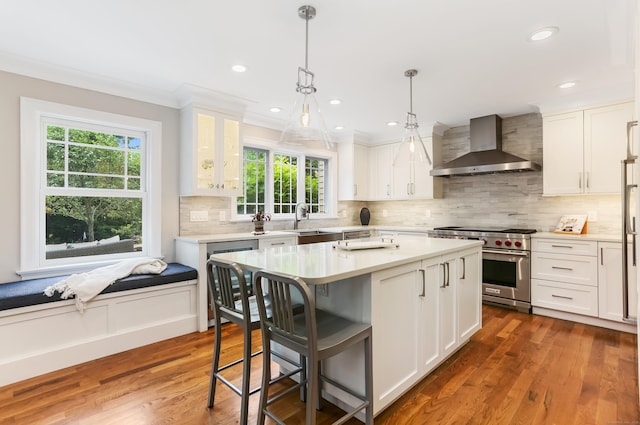 4 Reimer Rd, Westport, CT 06880 - kitchen featuring wall chimney range hood, designer stove, plenty of natural light, a breakfast bar, and crown molding