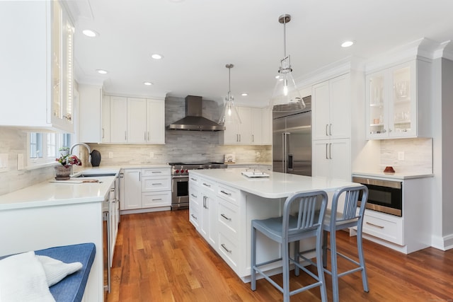4 Reimer Rd, Westport, CT 06880 - kitchen with wall chimney exhaust hood, high quality appliances, a kitchen island, white cabinets, and recessed lighting