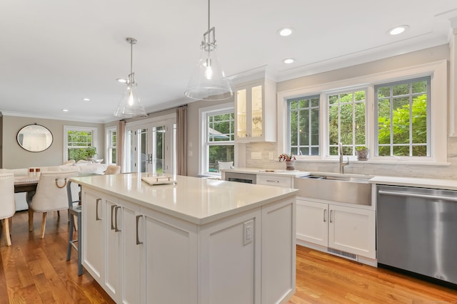 4 Reimer Rd, Westport, CT 06880 - kitchen featuring stainless steel dishwasher, ornamental molding, a kitchen island, open floor plan, and white cabinets