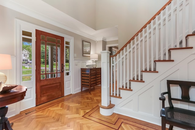 4 Reimer Rd, Westport, CT 06880 - entryway with stairs, a decorative wall, crown molding, and a wainscoted wall
