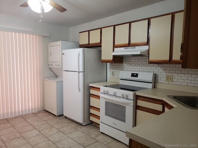 16 Lisa Ct Apt 7, Waterbury, CT 06704 - kitchen featuring under cabinet range hood, white appliances, stacked washer and clothes dryer, and tasteful backsplash