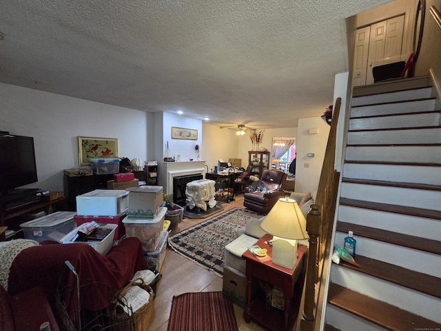 16 Seymour Rd Unit 2C, East Granby, CT 06026 - living room featuring stairs, wood finished floors, a textured ceiling, a ceiling fan, and a fireplace