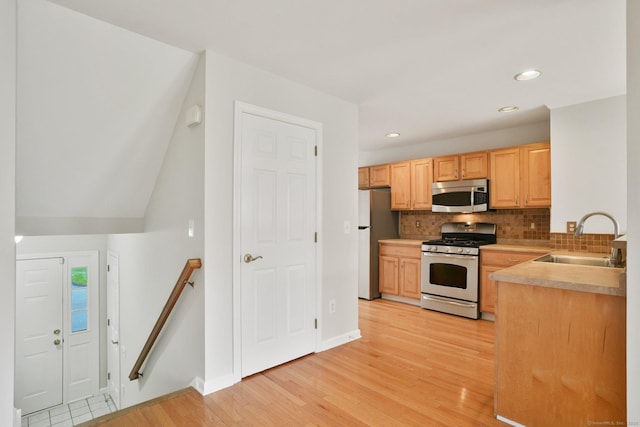 1802 Pinnacle Way Unit 1802, Danbury, CT 06811 - kitchen featuring stainless steel microwave, gas range gas stove, freestanding refrigerator, backsplash, and light wood finished floors