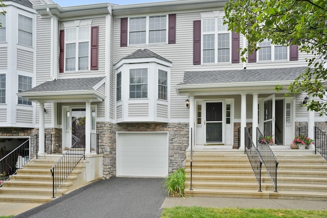 1802 Pinnacle Way Unit 1802, Danbury, CT 06811 - townhome / multi-family property featuring stone siding, asphalt driveway, an attached garage, roof with shingles, and a porch