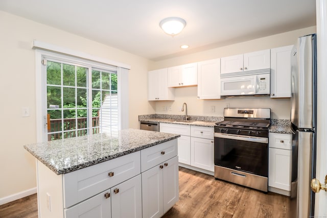 2303 Eaton Ct Unit 2303, Danbury, CT 06811 - kitchen featuring appliances with stainless steel finishes, wood finished floors, white cabinets, a kitchen island, and light stone countertops