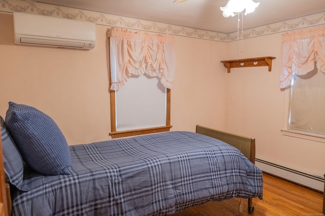 56 Franklin St, Vernon, CT 06066 - bedroom featuring a wall mounted air conditioner, a baseboard radiator, and wood finished floors