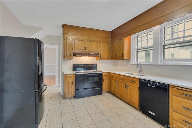 219 Jordan Ln, Wethersfield, CT 06109 - kitchen featuring black appliances, under cabinet range hood, light tile patterned flooring, light countertops, and brown cabinets
