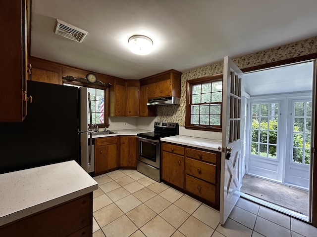 364 Locust Rd, Harwinton, CT 06791 - kitchen with stainless steel electric range oven, freestanding refrigerator, under cabinet range hood, light countertops, and brown cabinetry