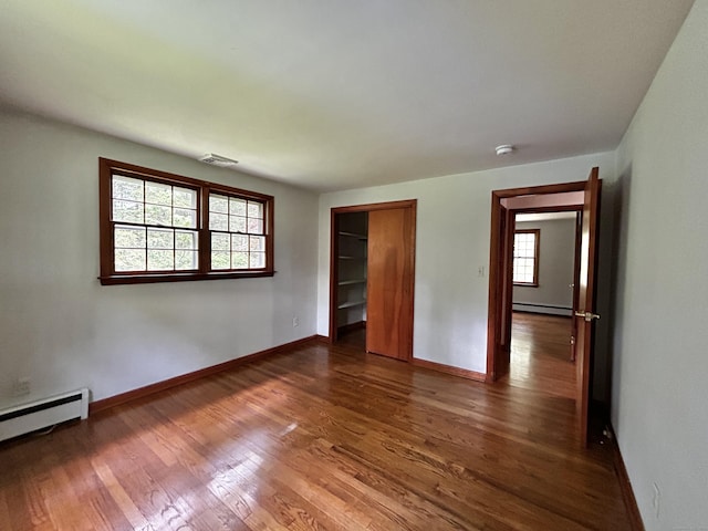364 Locust Rd, Harwinton, CT 06791 - unfurnished bedroom with a baseboard heating unit, dark wood finished floors, a baseboard radiator, and a closet