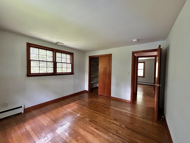 364 Locust Rd, Harwinton, CT 06791 - unfurnished bedroom with a baseboard heating unit, dark wood finished floors, a baseboard radiator, and a closet