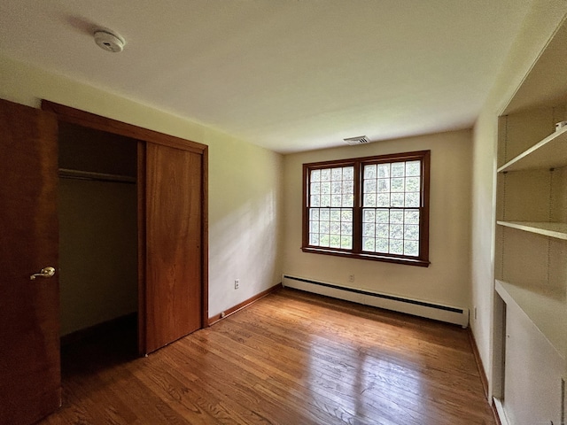 364 Locust Rd, Harwinton, CT 06791 - unfurnished bedroom featuring baseboard heating, wood finished floors, and a closet