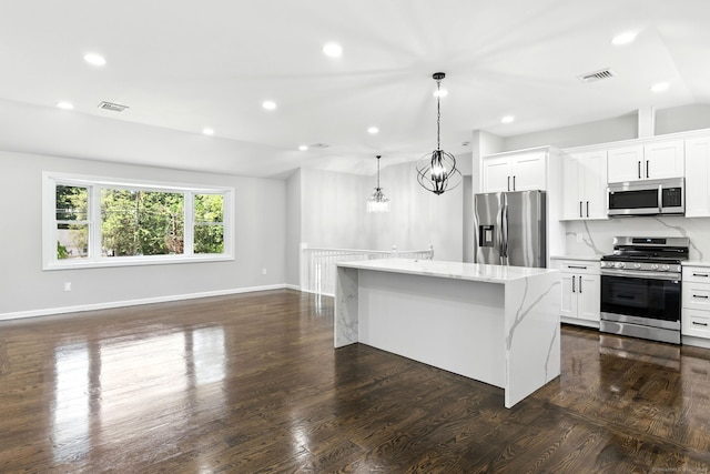 15 Beech St, North Branford, CT 06471 - kitchen featuring stainless steel appliances, a kitchen island, light stone counters, a chandelier, and dark wood finished floors
