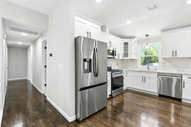 15 Beech St, North Branford, CT 06471 - kitchen with appliances with stainless steel finishes, dark wood finished floors, white cabinets, tasteful backsplash, and decorative light fixtures