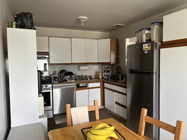 12 Cedar Ct Unit D, East Haven, CT 06513 - kitchen featuring stainless steel appliances, white cabinets, and dark countertops