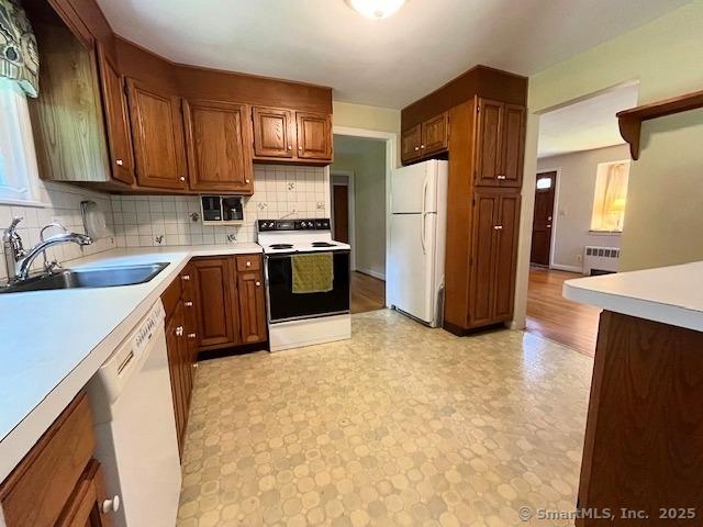 49 Geneva Ave, West Hartford, CT 06107 - kitchen featuring white appliances, light floors, radiator, light countertops, and decorative backsplash