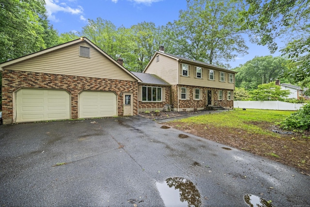64 Melcon Dr, Southington, CT 06489 - colonial home featuring a chimney, brick siding, driveway, and a garage