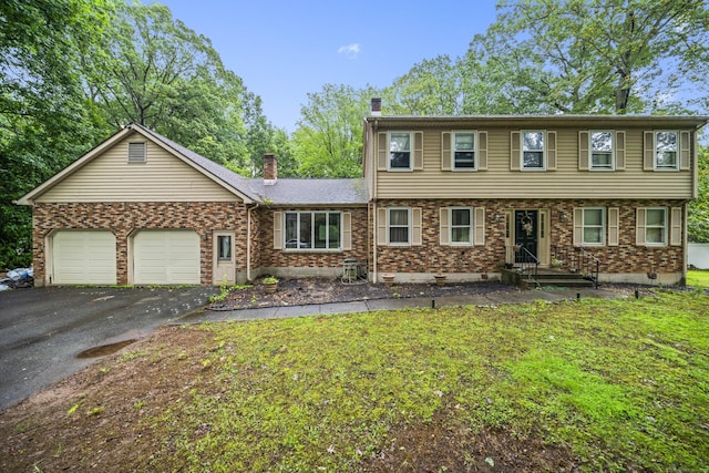64 Melcon Dr, Southington, CT 06489 - colonial home featuring a chimney, driveway, a garage, and brick siding