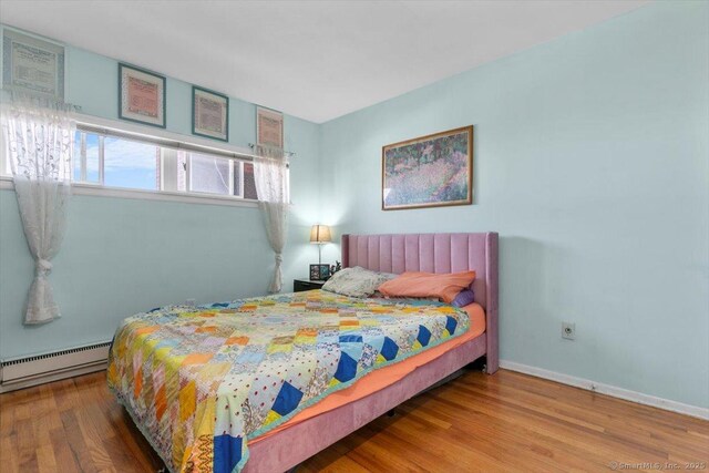 230 W Walk Walk Unit 230, West Haven, CT 06516 - bedroom featuring a baseboard heating unit and wood finished floors