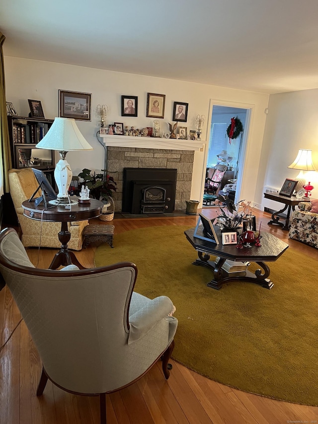 living area featuring a stone fireplace and wood finished floors