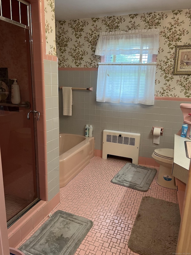 bathroom featuring radiator heating unit, wallpapered walls, wainscoting, a stall shower, and tile walls