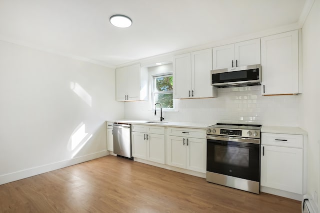 24 S Ave, Danbury, CT 06810 - kitchen with stainless steel appliances, decorative backsplash, a baseboard radiator, light wood-style flooring, and light countertops