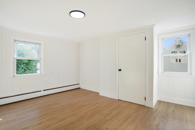 24 S Ave, Danbury, CT 06810 - unfurnished bedroom featuring light wood finished floors, baseboard heating, and a decorative wall