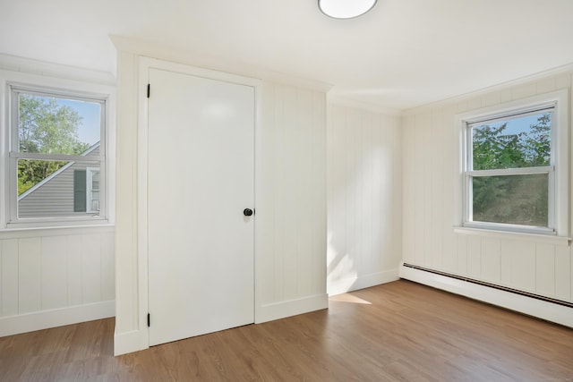 24 S Ave, Danbury, CT 06810 - unfurnished bedroom with multiple windows, wood finished floors, a baseboard radiator, and crown molding