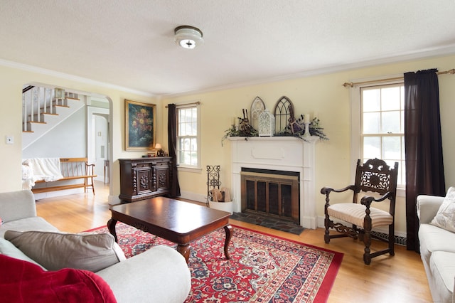 41 Northridge Ave, Torrington, CT 06790 - living area with ornamental molding, wood finished floors, stairs, a fireplace with flush hearth, and arched walkways